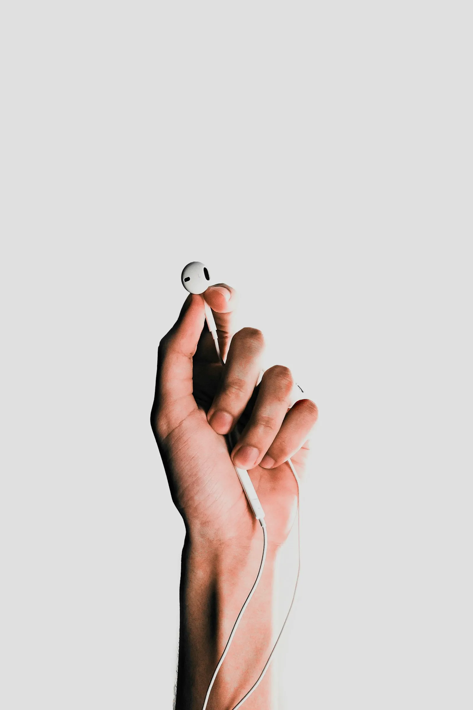 Person holding Apple AirPods, ready to connect for Live Listen